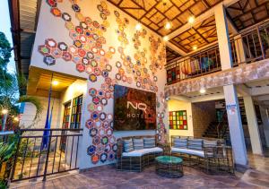 um edifício com dois bancos e uma árvore pintada na parede em NQ Hotel Orinoquia em Villavicencio