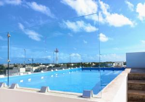 a large swimming pool with a glass wall at Cozy and spacious apartment by Tulum 10 in Tulum