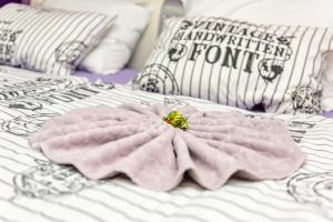 - un lit avec une couverture rose et une fleur dans l'établissement MaJo Apartma Punta, à Piran