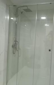 a shower with a glass door in a bathroom at Casinha Alice in Nazaré