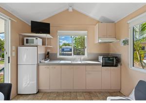 a kitchen with a white refrigerator and a window at Discovery Parks - Ayr in Ayr