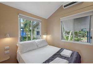 a bedroom with a bed and two windows at Discovery Parks - Ayr in Ayr