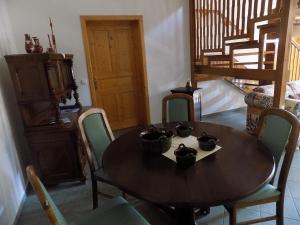 jadalnia z drewnianym stołem i krzesłami w obiekcie Platán Panzió w mieście Nyúl