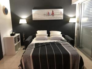 ein Schlafzimmer mit einem Bett mit einer schwarzen Wand in der Unterkunft Gîte Noirmoutier-en-l'Île, 2 pièces, 2 personnes - FR-1-426-515 in Noirmoutier-en-l'lle