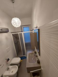 a bathroom with a sink and a toilet and a mirror at Appartamento nel cuore di Porto Azzurro in Porto Azzurro