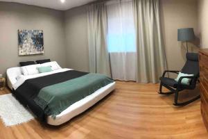 um quarto com uma cama grande e uma cadeira em Casa de Férias em Villa Nogueira