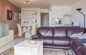 sala de estar con sofá de cuero marrón y cocina en Residentie Zon Zee Ref, 20, en Ostende