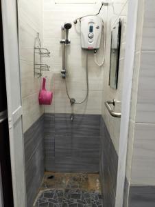 ein Bad mit einer Dusche und einem rosa Behälter in der Unterkunft Mahsuri Homestay in Jitra