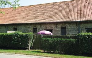 una sombrilla rosa frente a un edificio de ladrillo en Amazing Apartment In Diksmuide With Kitchen, en Dixmuda