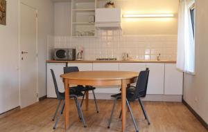 uma pequena cozinha com uma mesa de madeira e cadeiras em Amazing Apartment In Diksmuide With Kitchen em Diksmuide