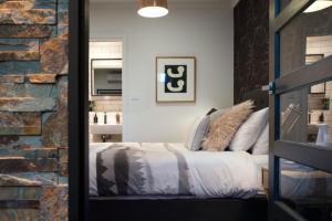 a bedroom with a bed and a brick wall at East St 3 in Daylesford