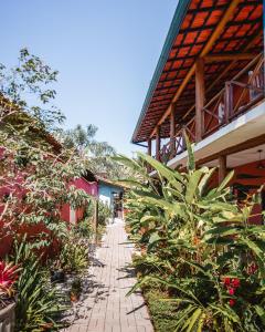 a brick walkway in front of a building with plants at Pousada Canto do Dado Praia de Itamambuca in Ubatuba