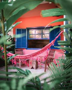 a house with a hammock in front of it at Pousada Canto do Dado Praia de Itamambuca in Ubatuba