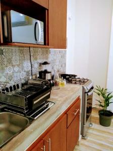 a kitchen with a sink and a stove top oven at Cozy and spacious apartment by Tulum 10 in Tulum
