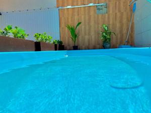 a large blue swimming pool in a building at Village Caranguejo - Flat com 02 Quartos in Aracaju
