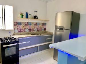 a kitchen with a stainless steel refrigerator and purple cabinets at Village Caranguejo - Flat com 02 Quartos in Aracaju