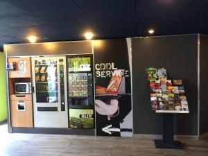 un magasin avec un distributeur automatique de coca cola dans l'établissement Cit'hotel Design Booking Evry Saint-Germain-lès-Corbeil Sénart, à Saint-Germain-lès-Corbeil