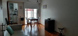 a living room with a table and chairs and a kitchen at Departamento Vicente Lopez sobre Av Maipu in Vicente López