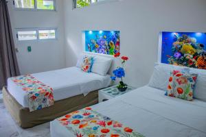 a bedroom with two beds and a painting on the wall at Las Fridas in Bacalar