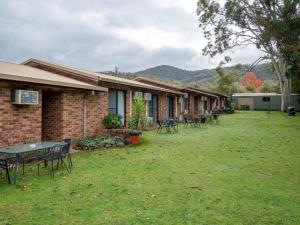 a row of houses with tables and chairs in the yard at Eildon Parkview Motor Inn Room 2 in Eildon