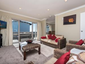 un soggiorno con divano, sedie e finestra di A Beach Barn Haven - Papamoa Holiday Home a Papamoa
