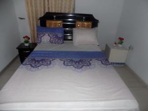 1 dormitorio con 1 cama blanca grande con almohadas azules en Great Secured 1Bedroom Service Apartment ShortLet-FREE WIFI - Peter Odili RD - N29,000, en Port Harcourt