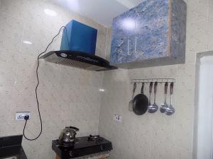 cocina con fogones y armario azul en Great Secured 1Bedroom Service Apartment ShortLet-FREE WIFI - Peter Odili RD - N29,000, en Port Harcourt
