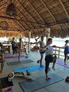 a group of people doing yoga on the beach at Olas Permanentes El Zonte in El Zonte