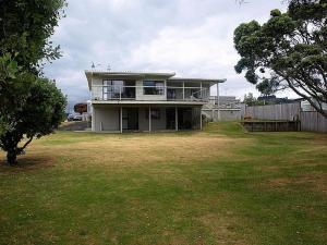 a large house with a large yard with a yard at Waihi Beach Break - Waihi Beach Bach in Waihi Beach