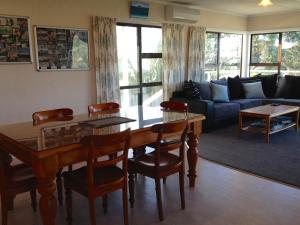 a living room with a table and a couch at Waihi Beach Break - Waihi Beach Bach in Waihi Beach