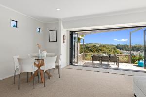 a dining room with a table and chairs and a large window at Marina Views - Tutukaka Holiday Home in Tutukaka