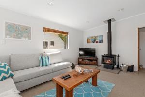 a living room with a couch and a fireplace at Marina Views - Tutukaka Holiday Home in Tutukaka