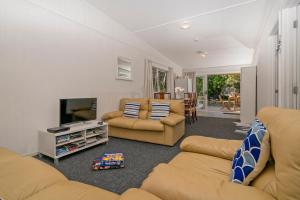 sala de estar con 2 sofás y TV en Rangimarie on Kenwood- Matarangi Holiday Home, en Matarangi