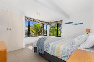 a bedroom with a bed and a large window at Marina Views - Tutukaka Holiday Home in Tutukaka