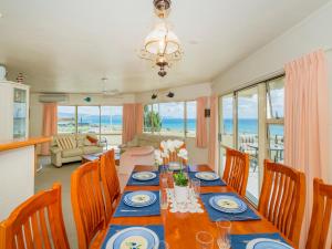 - une salle à manger avec une table et une vue sur l'océan dans l'établissement Easties Manner - Rings Beach Holiday Home, à Matarangi