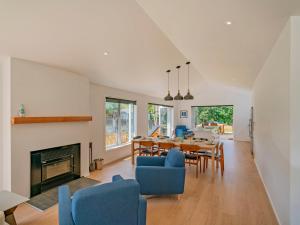 a dining room and living room with a table and chairs at Hot Water Bach - Hot Water Beach Holiday Home in Hotwater Beach