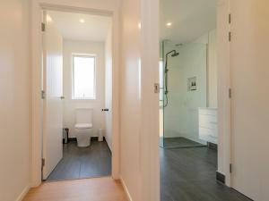 热水海滩Hot Water Bach - Hot Water Beach Holiday Home的浴室配有马桶和玻璃淋浴房 更多22张照片