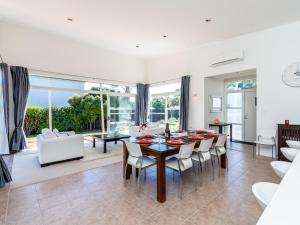 a dining room and living room with a table and chairs at Magnifique - Mangawhai Holiday Home in Mangawhai