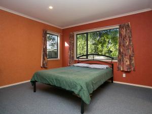1 dormitorio con cama y ventana en Laid Back on Lakewood - Taupo Holiday Home en Taupo
