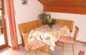 einen Esstisch mit einer Blumenvase darauf in der Unterkunft Awesome Apartment In Nesselwang With Kitchenette in Nesselwang