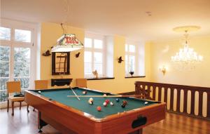 a living room with a pool table and a chandelier at Herrenhaus Lbbenow in Uckerland