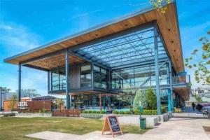 a large glass building with a sign in front of it at Industrial chic barndominium w/ high ceilings in Houston