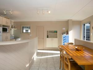 a kitchen and dining room with a wooden table at Perfect Position - Motuoapa Holiday Home in Turangi