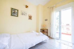 a bedroom with a bed and a large window at The Green Maisonette in Siviri
