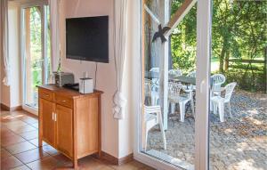 a living room with a screened in porch with a television at Awesome Home In Karwesee With Sauna in Karwesee