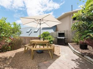 a picnic table and an umbrella in a backyard at Central Spacious Family House - Paihia House in Paihia