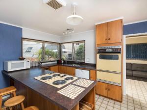 a kitchen with wooden cabinets and a stove top oven at Central Spacious Family House - Paihia House in Paihia
