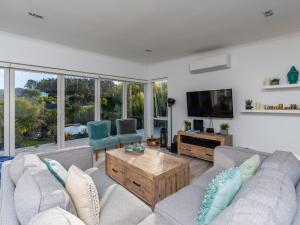 a living room with two couches and a tv at Little Pearl of Vista Verano - Mangawhai Home in Mangawhai