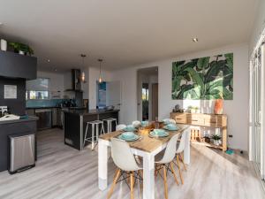 a kitchen and dining room with a table and chairs at Little Pearl of Vista Verano - Mangawhai Home in Mangawhai