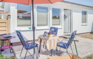 eine Terrasse mit einem Tisch, Stühlen und einem Sonnenschirm in der Unterkunft Ferienhaus Zum Anleger H in Hohen Wieschendorf